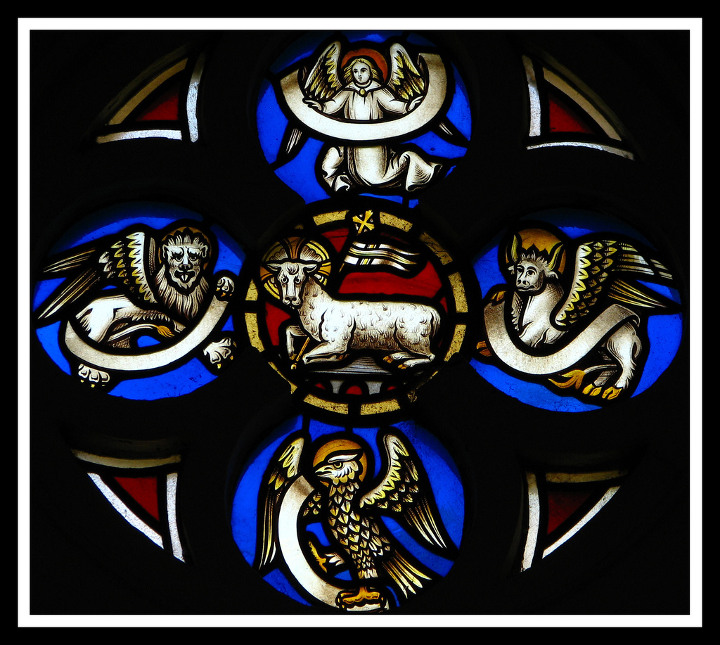 Animal icons of the four gospels on stained glass. Clockwise: angel, bull, eagle, lion